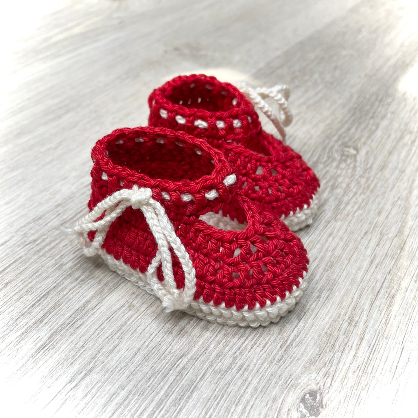 Egyedi horgolt baba cipő újszülött méretben piros és fehér pamut fonal